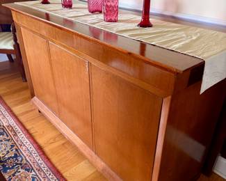 sleek mid-century modern wooden credenza featuring a warm honey finish and clean-lined cabinet doors