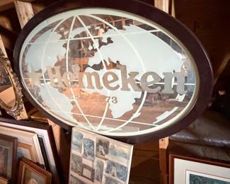 vintage oval Heineken beer advertising mirror featuring a frosted world map design and a dark wood frame
