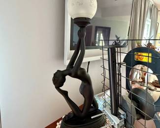 Art Deco-style figural table lamp featuring a matte black kneeling female sculpture holding a frosted white glass globe