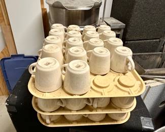 stack of cream-colored, speckled ceramic mugs stored in Cambro Camrack Cup Keepers