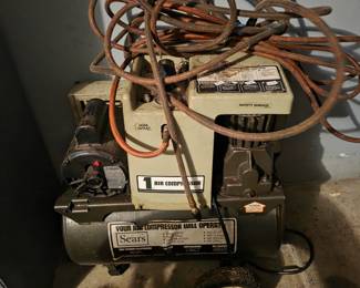 Sears air compressor with a coiled hose.