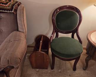 Same Victorian balloon-back chair shown against the wall, near an upholstered sofa and a small wood folding rack.