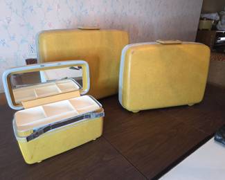 Same luggage set with the small train case opened, showing the fitted mirror and interior compartments.