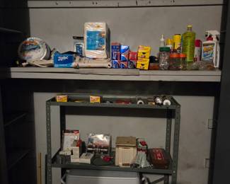 Metal shelving unit with garage supplies, including a red and white cooler on the bottom shelf.