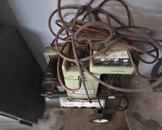 Sears twin-cylinder portable air compressor on wheels in avocado green with attached rubber air hose, suitable for inflating, spray painting, and running air tools.
