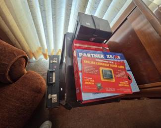 ECTACO Partner X5/X8 electronic English-Polish translator system with the Lets Talk American English Language Tutor Card, still in retail packaging, plus a vintage black hard-shell briefcase and a leather cassette storage case.