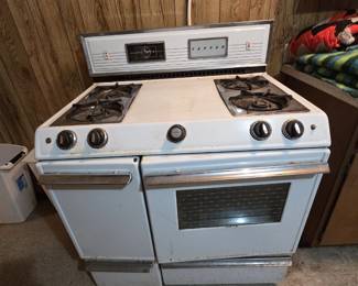 Vintage Tappan 40-inch gas range in white porcelain enamel with four burners, double oven doors, chrome trim, and the original backsplash control panel with built-in clock; a mid-century kitchen piece suitable for restoration.