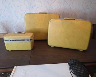 Vintage mustard-gold hardshell luggage set, three pieces, in a classic mid-century style.