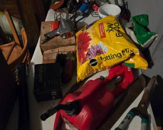 Garage area with a bag of potting mix, gardening tools, and assorted hand tools.