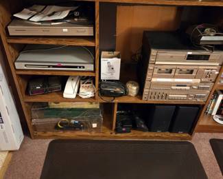 Lower shelves of the same unit with additional DVD players and electronic components.