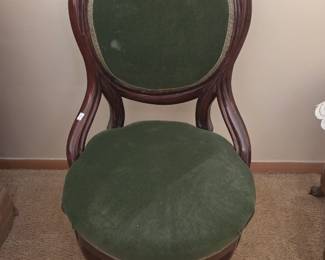 Victorian-style balloon-back side chair with a carved wood frame and green upholstered seat and back.