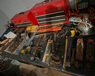Red Craftsman tool chest on a workbench, surrounded by assorted hand tools.