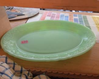 Jadeite-green oval serving platter with a scalloped edge and embossed floral rim design.