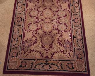 Ornate area rug in burgundy and tan with a floral medallion pattern, oriental style.
