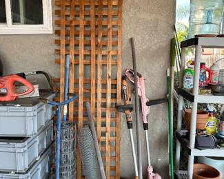 Lattice panel on its side with finished rail top,, wire, fencing, driveway, broom, 2 weedeater