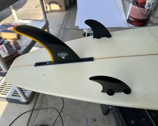 Triple fins on breaker surfboard