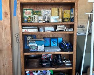 Oak bookshelf, router, bicycle helmet, cookbooks, brass lamp 