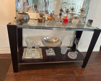 Entry or console table with glass top inside chrome strip on dark wood base is 19.5 inches deep and 49.5 inches wide