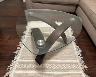 Coffee table with glass and wood and stainless details is 34 inches at widest in triangular pattern