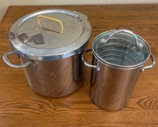 iw- This stainless steel cookware set features two essential pieces designed for versatile cooking. The set includes a large pot with a secure lid that has a gold-tone handle for easy lifting, and a smaller tall pot with dual handles and an inner removable rack for steaming or frying. The smaller pot measures approximately 8 inches in height and 7.5 inches in diameter, ideal for various cooking needs. Made of durable stainless steel, these cookware pieces boast a polished silver finish, providing both functionality and a sleek, modern look suitable for any kitchen.