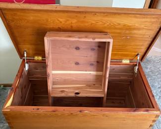 cw- This rustic wooden blanket chest offers a charming and functional storage solution, featuring distinct dovetail joinery that highlights the craftsmanship. The chest measures 28.5 inches tall, 44 inches wide, and 22 inches deep, providing ample space for blankets and other items. Constructed from warm-toned wood, the chest has a smooth finish and includes a hinged lid with interior compartmentalization for organized storage. The underside features scalloped detailing, adding a touch of rustic elegance to its sturdy, classic design.