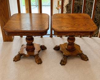 gi- This elegant set of two dark oak pedestal end tables features intricate carved detailing and distinctive claw feet, adding a touch of traditional craftsmanship to any room. Each table stands 20.5 inches tall and measures 22.5 inches in width and depth, offering a compact yet sturdy surface. The rich oak wood grain is beautifully showcased, highlighting the natural warmth and durability of the material. Perfect for complementing classic decor or serving as statement pieces in your living space.