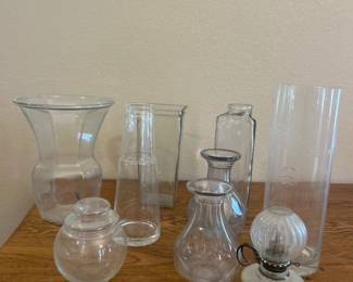 ks- This set features an assortment of decorative glassware pieces, including vases and bottles of varying shapes and sizes. Each piece is made from clear transparent glass, showcasing a sleek and classic design. Notably, one tall cylindrical vase measures approximately 9 inches in height and features subtle etched patterns for added decorative appeal. Perfect for home decor, floral arrangements, or as collectible glass pieces.