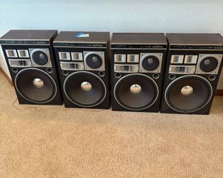 cl- This set features four Pioneer CS-903 speakers known for their robust sound quality and classic design. Each speaker showcases a vintage aesthetic with wood-finished cabinets and multi-driver front panels including large woofers, midrange, and tweeters. The speakers are crafted from durable materials and offer a maximum input power of 300 watts and nominal input power of 180 watts, providing powerful, clear audio performance. Their brown color and retro style make them a perfect addition for vintage audio enthusiasts or collectors.