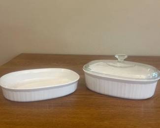 kd- This elegant set includes two white ceramic baking dishes, perfect for a variety of cooking and baking needs. The smaller dish measures approximately 11 inches in length and 2.5 inches in height, while the larger dish is slightly deeper at about 4.5 inches tall and comes with a clear glass lid featuring a convenient handle for easy lifting. Both dishes feature a smooth finish with subtle vertical ribbing on the exterior, enhancing grip and aesthetic appeal. Ideal for casseroles, roasting, and serving, these durable ceramic dishes offer excellent heat retention and an attractive presentation for your kitchen and dining table.