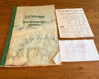 bb- This collectible features the 100th Anniversary Edition of The New Braunfelser Zeitung, showcasing historical significance and vintage charm. The edition includes a special cover marked with a green spine and aged, yellowed pages that highlight the paper's authenticity and age. Accompanying the newspaper are two additional items: a walking tour guide of historic New Braunfels detailing over 75 old homes, buildings, and points of interest, and a memorandum note dated September 1936 with old-style typography. This edition is a valuable piece of New Braunfels history, ideal for collectors or enthusiasts of local heritage and vintage newspapers.