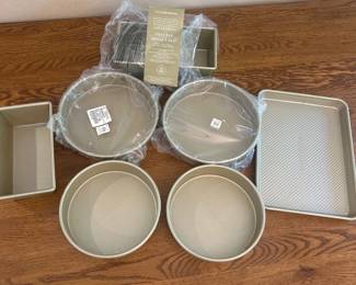 fg- This Gold Touch Williams Sonoma Baking Set includes an assortment of high-quality baking pans perfect for various baking needs. The set features round cake pans, loaf pans, a square pan, and a rectangular baking pan all with a smooth gold-tone finish. Each piece is crafted to resist sticking and promote even baking. The dimensions of the rectangular loaf pan are approximately 9.5 inches in length, 4.75 inches in width, and 3 inches in height, making it ideal for baking bread, cakes, and more. This durable and stylish set is a versatile addition to any kitchen, combining functionality with elegant design.