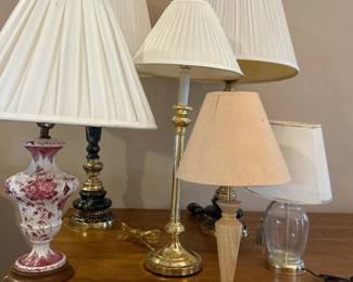 ga- This collection features assorted table lamps showcasing a variety of unique designs and materials. Included are lamps with elegant pleated white shades, intricate bases in brass, marble, and ceramic finishes, and diverse color schemes including red floral, beige, and clear glass. The sizes vary, offering versatile options for different room settings. These lamps blend classic and vintage aesthetics, perfect for enhancing the ambiance of any living space.