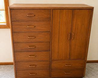 gm- This Gentleman's Chest features a combination of 9 spacious drawers and a wardrobe area, providing versatile storage options. Crafted from rich wood with a warm, medium-brown finish, it showcases clean lines and sturdy construction typical of vintage design. Measuring 49.5 inches tall, 44 inches wide, and 18 inches deep, it fits comfortably in most bedrooms or dressing areas. The wardrobe section includes two doors with ample shelving inside, perfect for hanging clothes or additional folded items. The chest drawers vary in size, ideal for organizing everything from accessories to larger garments.