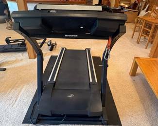 ii- This NordicTrack E 4400 treadmill features a robust black and silver frame with a spacious running belt designed for comfortable workouts. It includes an advanced digital console with multiple function buttons, clear display screens, and integrated speakers for an immersive exercise experience. The treadmill is equipped with safety key features and manual incline settings, making it suitable for users seeking both convenience and performance in their home fitness equipment. Its sturdy construction and user-friendly controls highlight its durability and ease of use.