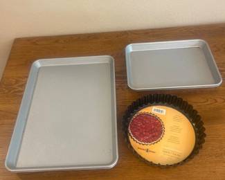 ke- This set of 5 assorted bakeware pieces features durable metal construction with a silver finish, perfect for various baking needs. Included are two rectangular baking sheets measuring approximately 11 x 9 inches and 10 x 6.5 inches, ideal for cookies, roasting, and sheet cakes. The set also includes three quiche/tart pans, one with a fluted edge measuring about 10 inches in diameter and 2 inches deep, designed for making tarts, quiches, and pies. These bakeware pieces are versatile in size and shape, suitable for both everyday baking and special culinary creations.