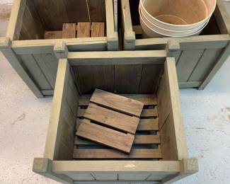 mn- Set of wooden crates designed for use as planters, each including small pallets inside and pots. These crates are constructed from sturdy wood with a rustic finish, featuring a greenish tone. The dimensions are approximately 19 inches in height and 18.25 inches in width, making them suitable for both indoor and outdoor gardening or decorative storage. The included planters complement the wooden structure, offering a natural and organized way to display plants.