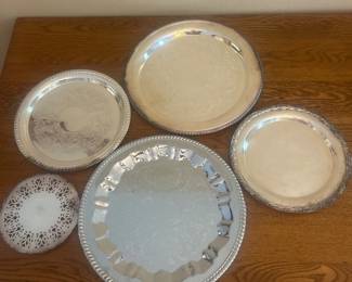 fp- This collection features a variety of silver plated platters, each showcasing unique designs and intricate detailing. The set includes platters of different sizes, with one measuring approximately 7 inches in diameter. One of these platters are unmarked with no stamp, adding to their distinctive vintage charm. Crafted from silver plated material, they exhibit a polished finish with some signs of wear, highlighting their authentic use and history. Perfect for collectors or as elegant serving pieces, these platters blend functionality with classic style.