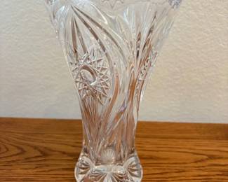 fm- This Nachtmann Bleikristall Florenz vase stands 8.5 inches tall and is crafted from high-quality lead crystal. Featuring intricate cut glass patterns, including starburst and swirling designs, it reflects light beautifully for an elegant display. The vase has a clear, sparkling finish with a scalloped rim and a sturdy, decorative base. Perfect for floral arrangements or as a standalone decorative piece, this vase combines classic craftsmanship with timeless style, making it a stunning addition to any home décor.