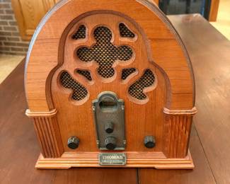 cq- This Thomas Collector's Edition Radio, Model 217, offers a charming vintage aesthetic with its classic wooden casing and intricate front grille design. Measuring 12.5 inches tall, 11.5 inches wide, and 8 inches deep, this radio features a warm wood finish that enhances its nostalgic appeal. The unit includes an AM/FM tuner with easy-to-use dials on the front and a speaker covered by a decorative mesh. The back panel provides ventilation and houses the power cord, with clear caution labels for safe use. A perfect addition to any retro or vintage collection, this radio combines timeless design with functional listening capabilities. Tested and seems to be working properly.