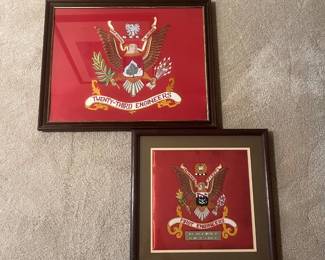 bw- This set features two beautifully framed embroidered crests representing the Twenty-Third Engineers and the First Engineers units. Each crest is meticulously stitched on a vibrant red fabric background, highlighting the detailed eagle insignia and unit banners. The Twenty-Third Engineers crest is larger and presented in a dark wooden frame, while the First Engineers crest is slightly smaller, surrounded by a tan mat and also housed in a matching dark wooden frame. The First Engineers piece includes a brass nameplate adding a personalized historic touch. Both pieces have sturdy hanging hardware on the back, and the frames have a classic, polished finish that enhances the vivid colors and craftsmanship. Ideal for collectors or veterans, these items celebrate military heritage with quality materials and detailed embroidery. Large Frame: 18in x 21.5 in Small Frame: 16.5 in x 16.5in