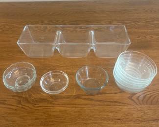jt- This assorted set of glass serving dishes features a variety of clear, durable glass bowls and a unique three-compartment rectangular serving tray. The dishes range approximately from 4 to 6 inches in diameter and around 2 inches in height, perfect for serving dips, snacks, or condiments. Crafted from transparent glass, these versatile pieces highlight a simple yet elegant design, ideal for enhancing your dining or entertaining experience. The set includes multiple small round bowls and a long rectangular divided tray for organized and stylish food presentation.