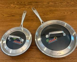 fh- This Chef's fry pan set includes two high-quality frying pans, measuring 8 inches and 10 inches in diameter. Each pan features a durable nonstick cooking surface for easy food release and hassle-free cleaning. Both pans come with matching stainless steel lids stamped with the 'CHEF'S' brand, ensuring optimal heat retention and moisture control. The pans have sturdy, ergonomically designed handles for comfortable and secure grip during cooking. Perfect for everyday use, this set combines functionality and quality for an efficient kitchen experience.