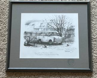 bp- Framed George A. Finley “Symbols of Freedom – 1989 Trabant with American Flag” print depicting an East German Trabant in Germany during the historic period surrounding the opening of the Berlin Wall. The artwork is double signed: Finley’s signature appears within the reproduced artwork, and the print is additionally hand signed by George A. Finley, personally inscribed and dated 1992 at lower right. The handwritten dedication references the recipients having been “in Germany when the Wall came down,” giving this particular example a direct personal connection to the historic subject. The print is captioned “Symbols of Freedom – 1989 / Trabant with American Flag.” Included with the framed artwork is Finley’s typed February 1990 account, “Trabant With American Flag,” explaining the December 1989 encounter that inspired the image, as well as an original handwritten note from Finley referring specifically to the purchaser’s “Trabi print.”