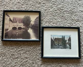 dh- Pair of vintage framed German city views depicting Nürnberg (Nuremberg), Germany, including the historic Heilig-Geist-Spital spanning the Pegnitz River. The smaller artwork is a hand-colored etching, pencil titled “Nürnberg” at lower left and pencil signed by the artist at lower right. The artist’s signature is visible but has not been definitively identified. The etching features detailed architectural linework with subtle hand-applied color. 8.7in x 10.7in Accompanied by a vintage framed photograph depicting the same historic Nürnberg river scene, making the two pieces an appealing matched grouping.
