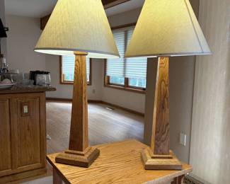 gd- This pair of Mission style table lamps features sturdy oak bases with a natural wood grain finish. Each lamp stands 36 inches tall and is topped with an 18-inch wide linen shade, providing a warm and inviting glow. The lamps combine classic craftsmanship with functional elegance, perfect for enhancing the ambiance of any living space. The oak construction ensures durability, while the neutral linen shades complement a variety of decor styles.