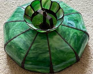 bc- This exquisite stained glass hanging lamp shade features a vibrant green color with swirling patterns, creating a timeless and elegant look. Measuring 24 inches in diameter with a 13-inch height to the top of the hook, it is made from beautifully crafted stained glass panels joined by dark metal framing. The lamp shade's unique scalloped design adds a decorative flair, making it a perfect addition for vintage or art nouveau inspired interiors.