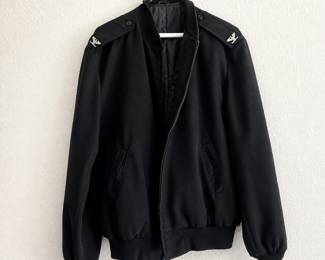 ce- This black military-style jacket features distinctive silver eagle emblems on both shoulder epaulets, adding a unique and bold detail to its design. Crafted in a long size 44, it offers a comfortable fit with ribbed cuffs and hem for a snug wear. The jacket includes a front zipper closure and two side pockets, combining functionality with classic style. The interior is smooth and lined, enhancing comfort and durability. Perfect for aficionados of military-inspired outerwear or those seeking a statement piece in their wardrobe.