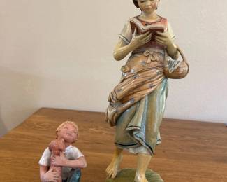 ky- This charming set of two child statues beautifully captures tender moments with exceptional detail. The first statue depicts a seated child holding a small dog, showcasing lifelike textures and earthy tones of muted white, blue, and brown. The second statue stands approximately 10 inches tall and features a barefoot child reading a book, draped in flowing garments painted in soft pastel shades of green, peach, and blue. Both pieces are crafted from durable material with a smooth finish, making them perfect for collectors or as decorative accents in any room.