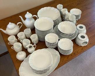 eu- This elegant Kaiser Porzellan dinnerware set from Bad Staffelstein, Bavaria, dates back to 1960-1970. Crafted from fine white porcelain, the set includes a variety of pieces such as teapots, cups, saucers, plates, and serving dishes. The porcelain is marked with the Kaiser Porzellan logo, reflecting its high-quality German craftsmanship. The timeless all-white color and delicate embossed detailing make it a classic addition to any table setting, suitable for both everyday use and special occasions.
