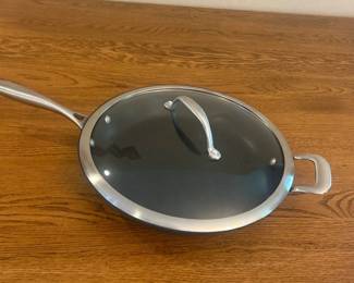 is- This CHEFS cookware set includes a saucepan and a skillet, both crafted with durable all-clad stainless steel. The skillet features a non-stick black cooking surface and comes with a snug-fitting glass lid with a stainless steel handle. The skillet measures approximately 10 inches in diameter, ideal for versatile cooking needs. The handles are sturdy, ergonomically designed, and marked with the CHEFS brand for authenticity. Both pieces combine high-quality materials with functionality, perfect for both professional chefs and home cooking.